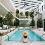 woman sitting by a beautiful indoor pool
